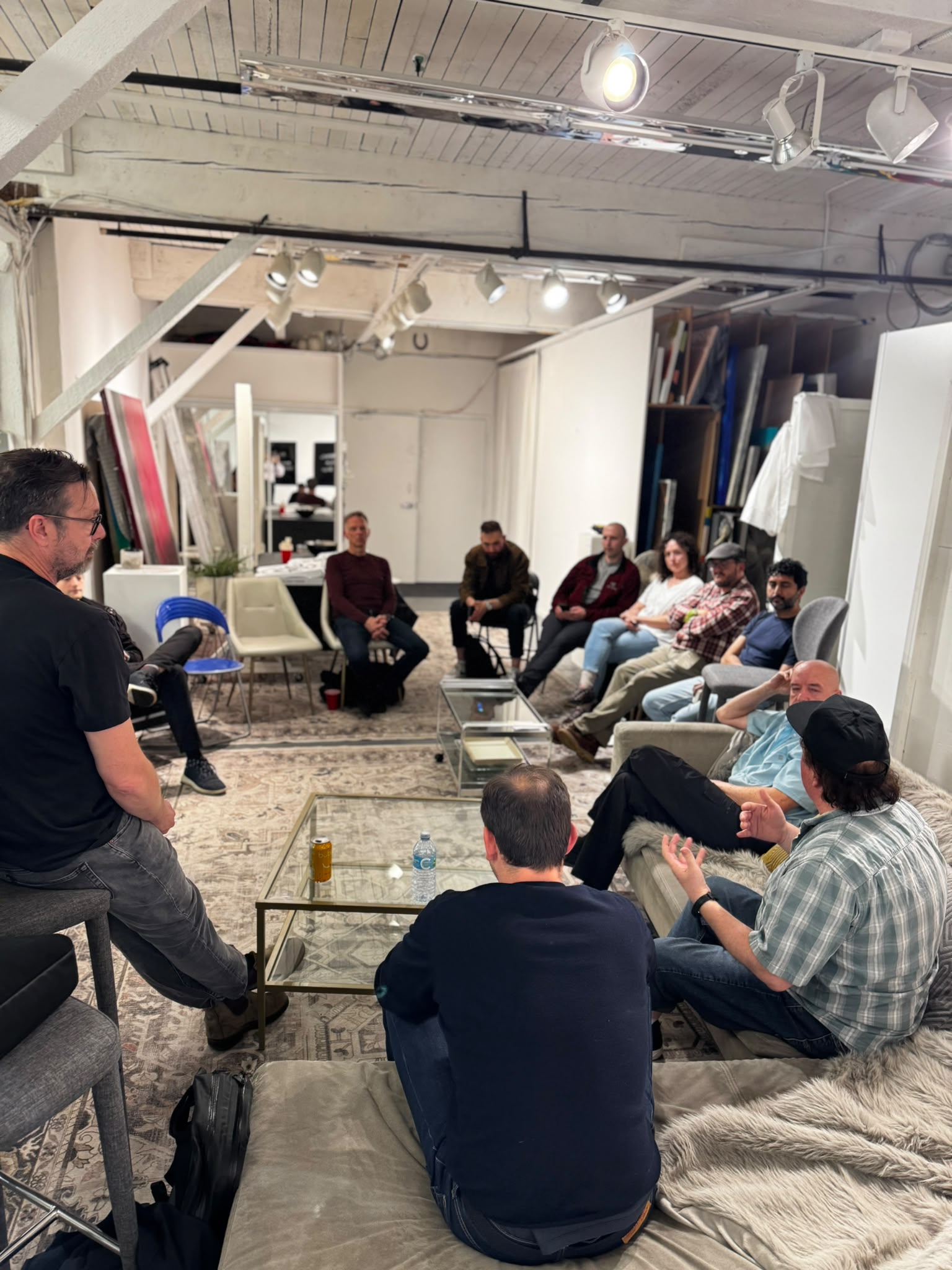 A participant gestures as others listen around the studio.